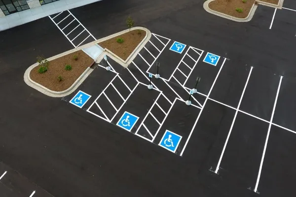 Aerial view of accessible stalls, access aisles, and white parking lot striping
