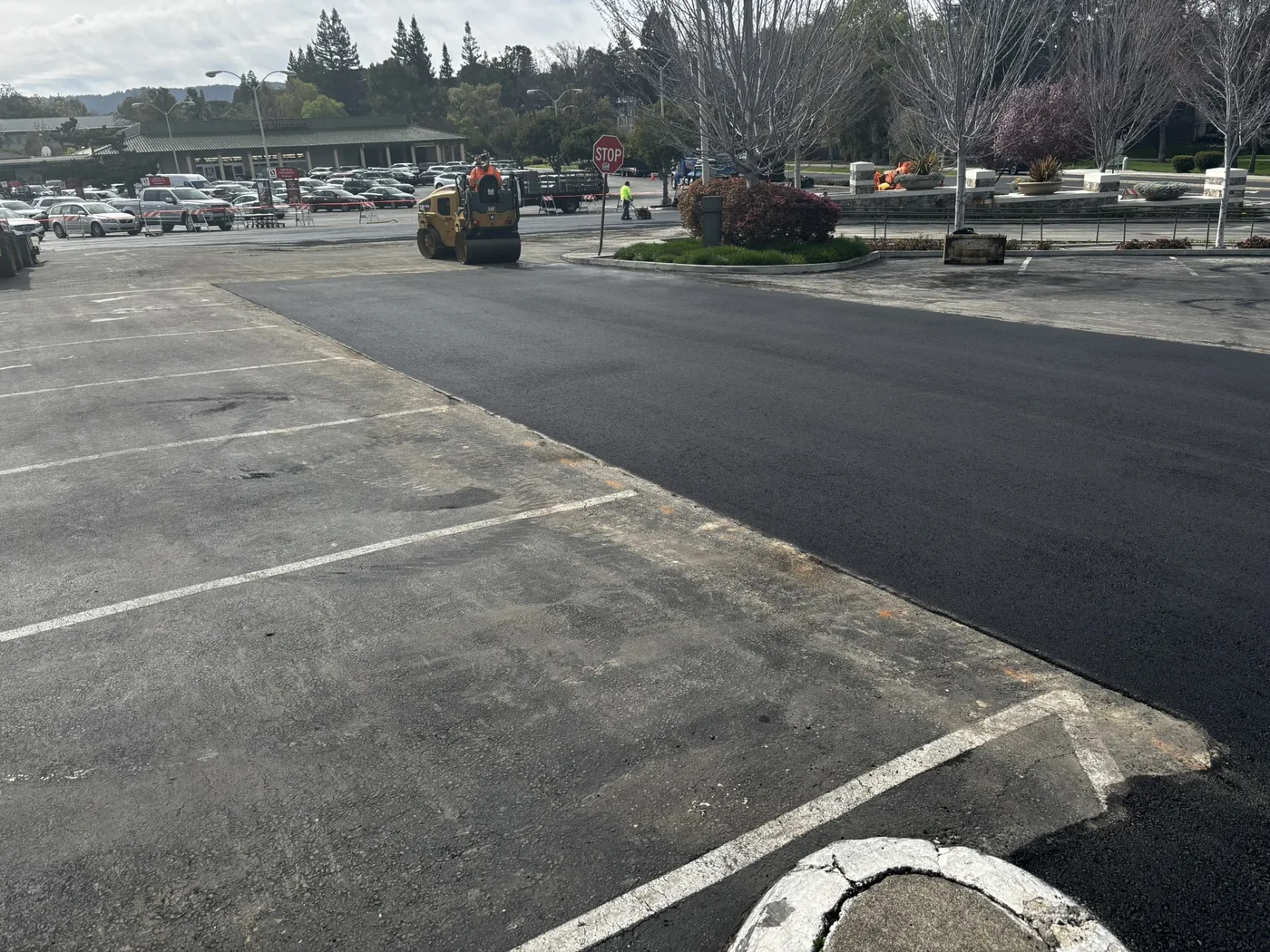 Fresh asphalt paving next to older parking lot pavement showing the edge of an overlay scope