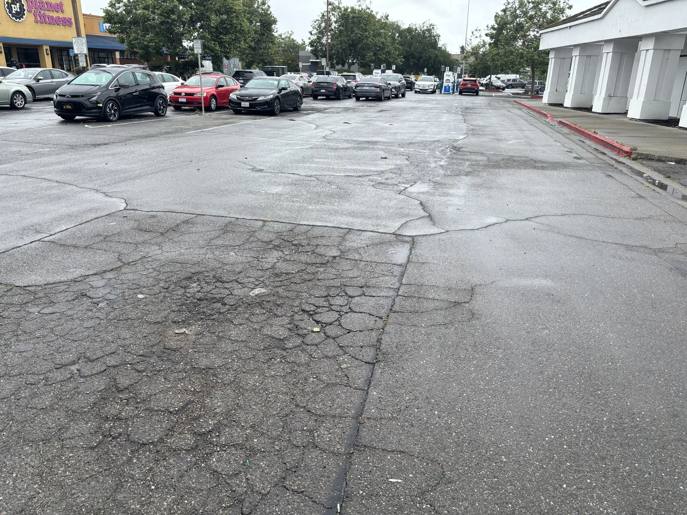 Commercial parking lot pavement with widespread cracking and failed asphalt areas