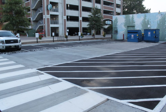 Commercial property using asphalt pavement alongside concrete crosswalks, flatwork, and service areas