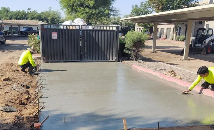 Workers finishing a newly poured reinforced concrete dumpster pad