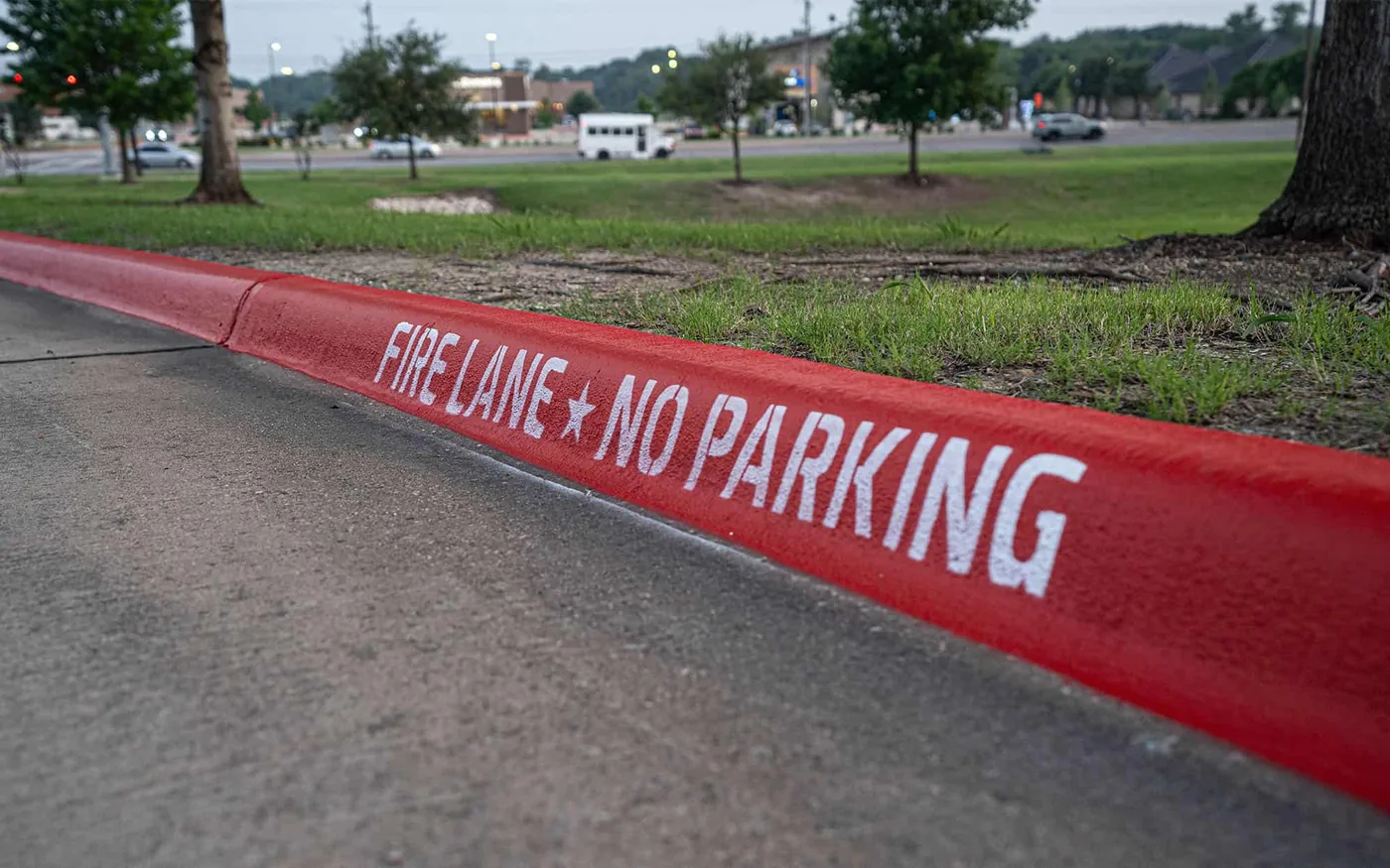 Red fire lane curb with white Fire Lane No Parking stencil