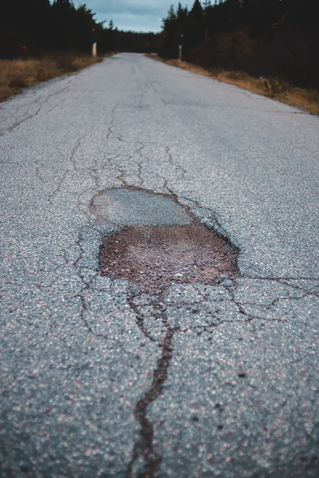 Pothole and failed asphalt during a parking lot pavement assessment